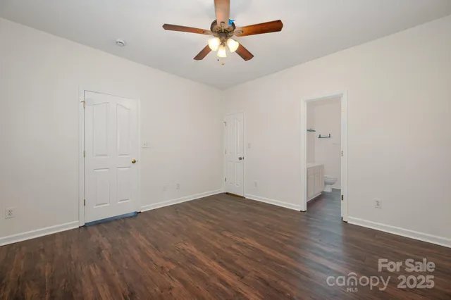 an empty room with wooden floor and a ceiling fan