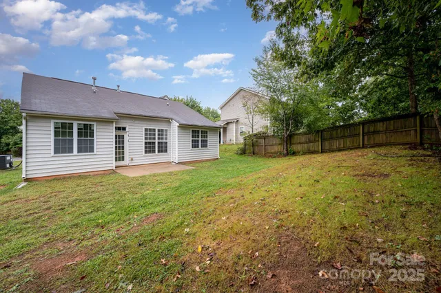 a backyard of a house with swimming pool and brick wall