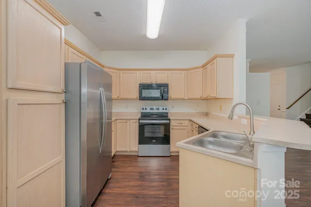 a kitchen with a refrigerator sink and wooden cabinets