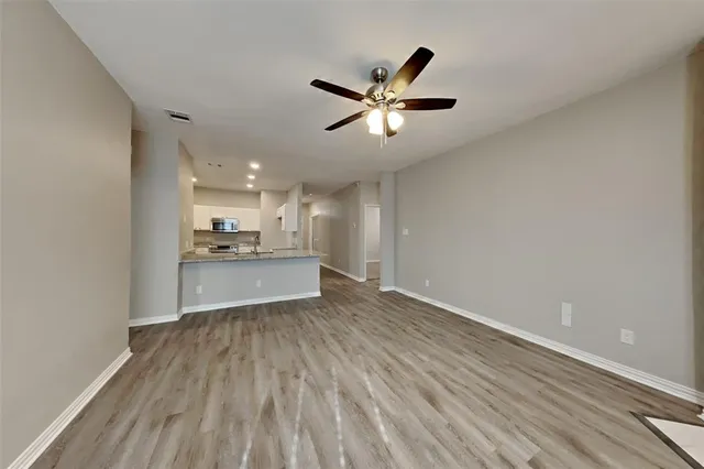 a view of a kitchen with a sink and wooden floor