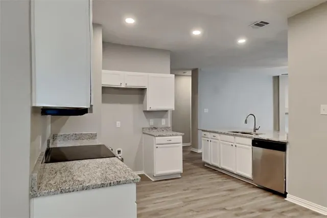 a kitchen with granite countertop a sink and a stove top oven
