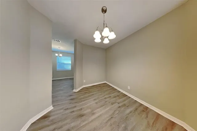 a view of wooden floor and a chandelier in a room