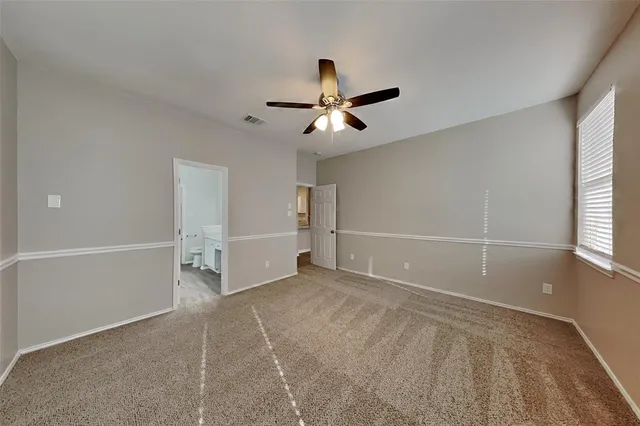 a view of a room with ceiling fan and window