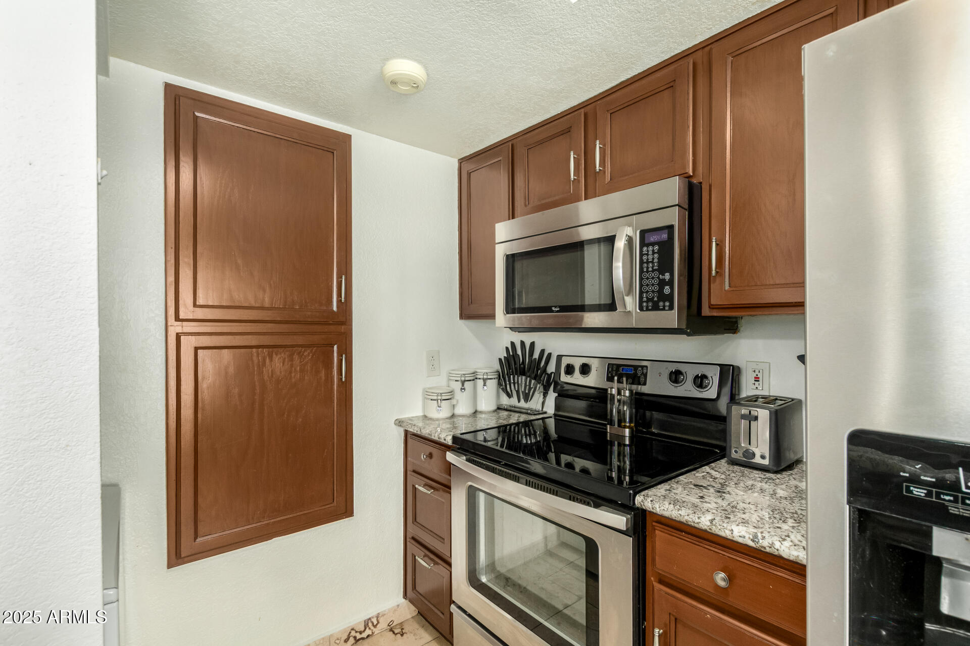9711 East Mountain View Road, Unit 2514 Scottsdale, AZ 85258 - Photo 9 of 26 a kitchen with stainless steel appliances granite countertop a stove microwave and refrigerator
