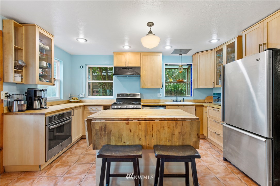 907 North 68th Street Seattle, WA 98103 - Photo 11 of 36 a kitchen with a refrigerator a stove a sink and a dining table