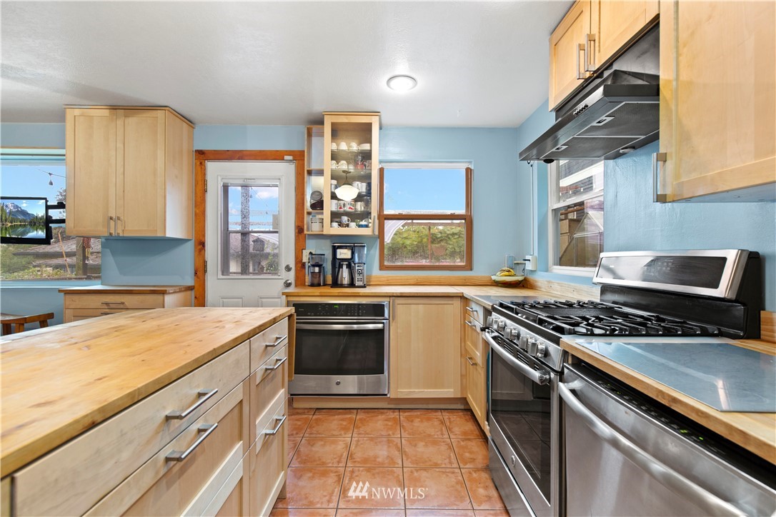 907 North 68th Street Seattle, WA 98103 - Photo 14 of 36 a kitchen with stainless steel appliances granite countertop a stove and a sink