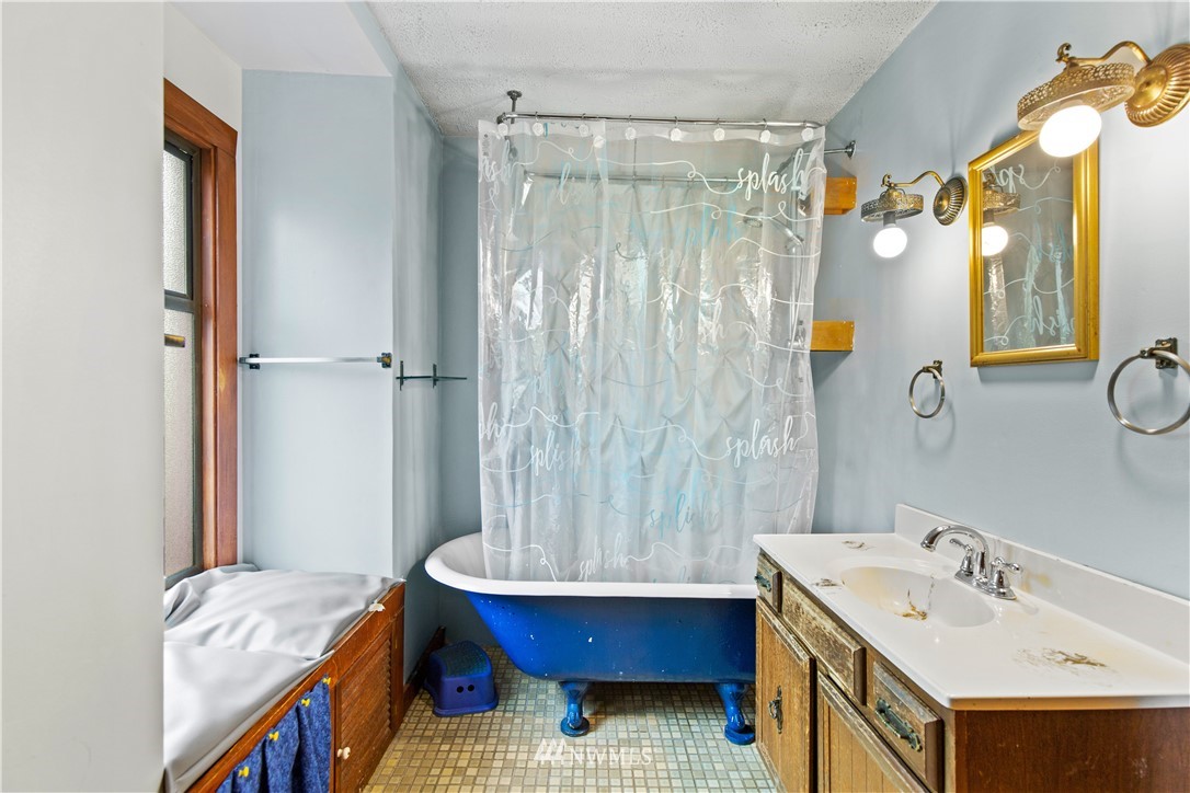 907 North 68th Street Seattle, WA 98103 - Photo 21 of 36 a bathroom with a granite countertop sink and a mirror