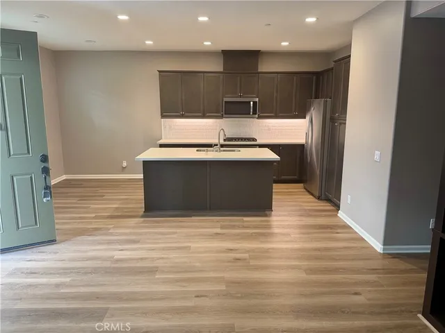 a view of kitchen with stainless steel appliances wooden floor