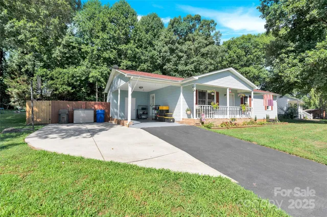a front view of a house with a yard and trees