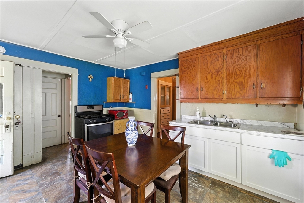 18-20 Eldridge Street Springfield, MA 01108 - Photo 7 of 42 a kitchen with a dining table chairs cabinets and stainless steel appliances