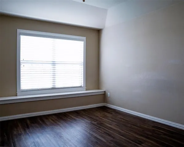 a view of a room with wooden floor and a window