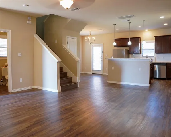 a view of kitchen with wooden floor and electronic appliances