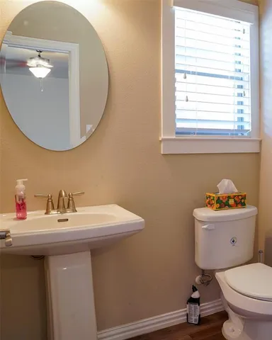a bathroom with a sink a toilet and a mirror