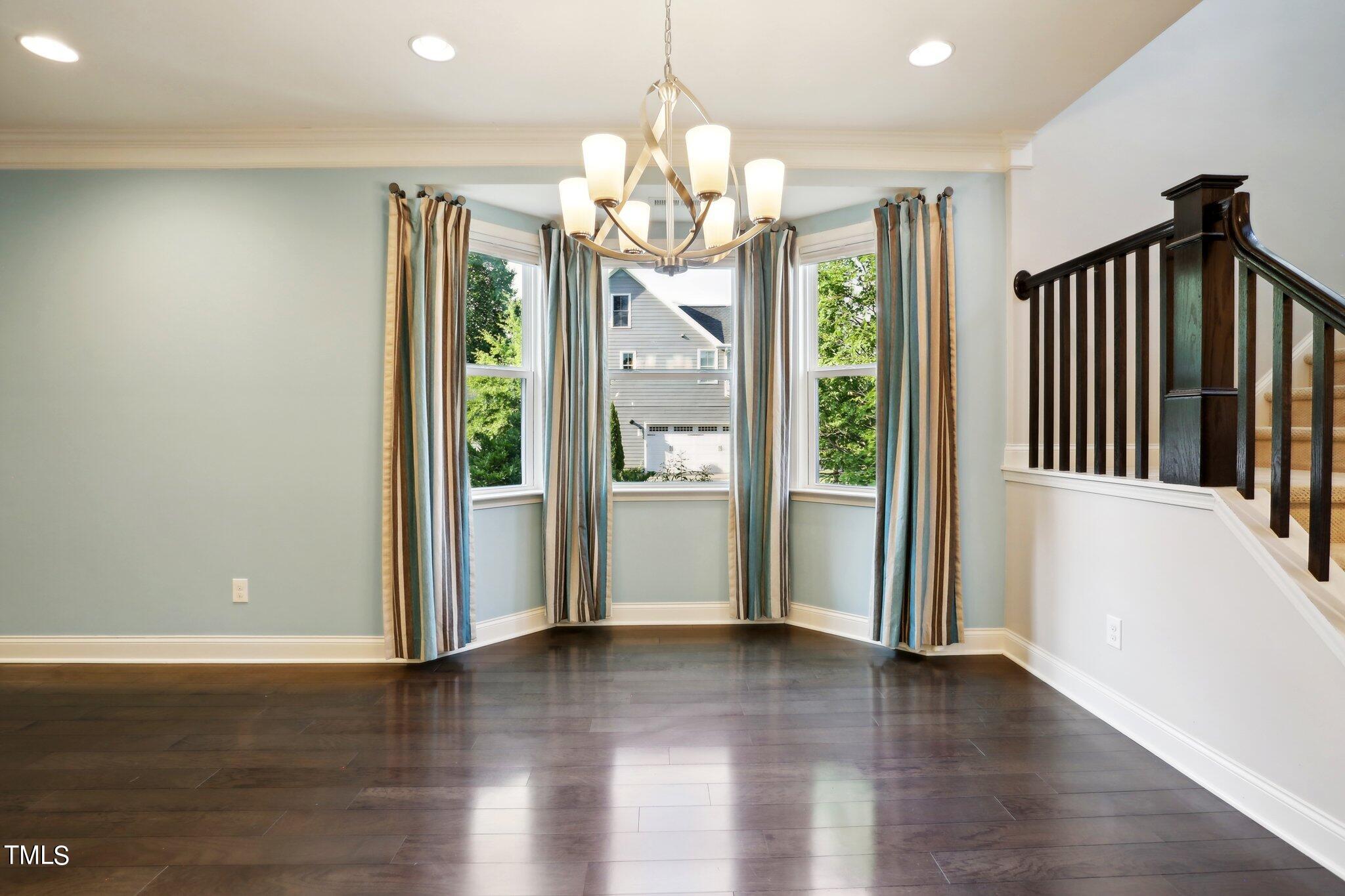 517 Plainview Avenue Raleigh, NC 27604 - Photo 11 of 58 an empty room with wooden floor chandelier and windows