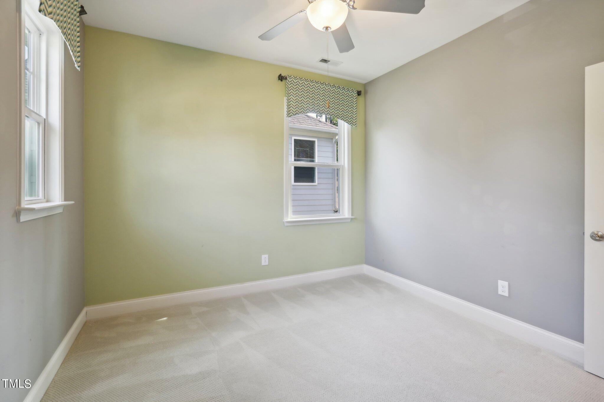 517 Plainview Avenue Raleigh, NC 27604 - Photo 31 of 58 an empty room with a chandelier fan and windows