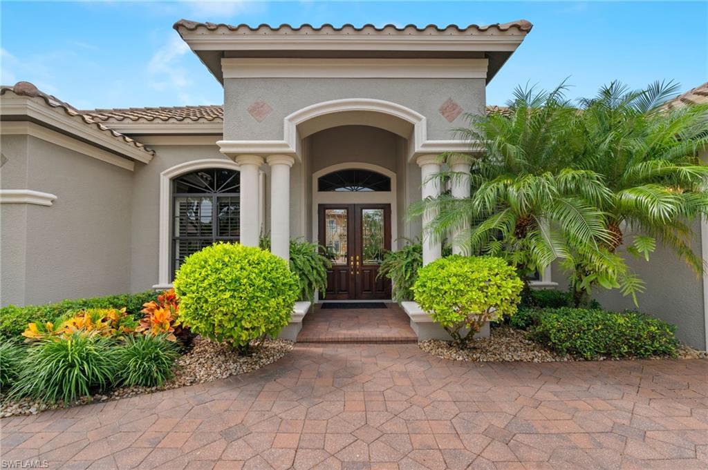 19961 Markward Crossing Estero, FL 33928 - Photo 2 of 5 a view of a house with large windows and flower plants