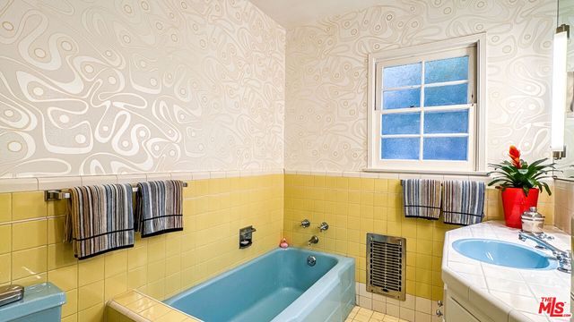 a bathroom with a tub sink and mirror