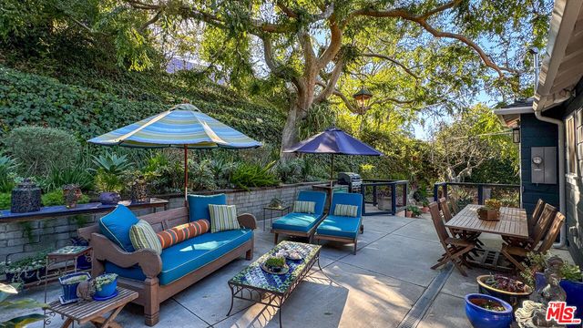 a view of backyard with outdoor seating and trees