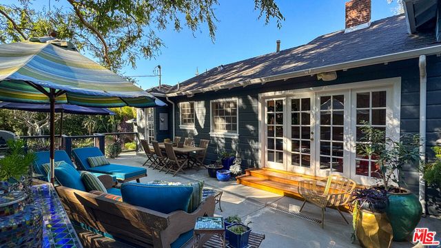 a view of a chairs and table in patio with a barbeque
