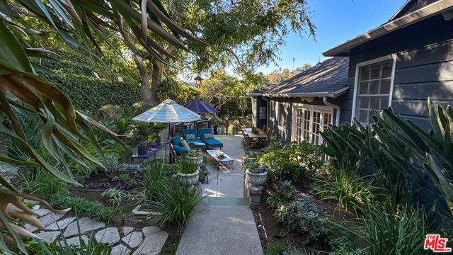 a view of house with yard and outdoor seating