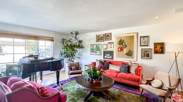 a living room with furniture potted plant and a large window