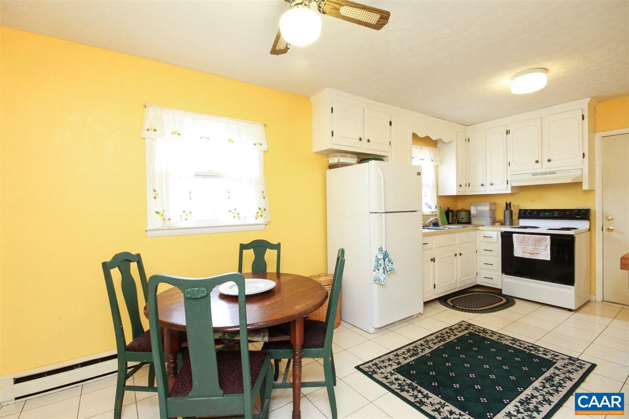 32 Stonewall Road Palmyra, VA 22963 - Photo 8 of 15 a kitchen with stainless steel appliances granite countertop a stove a refrigerator a microwave a dining table and chairs with wooden floor