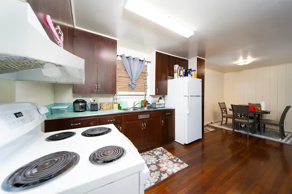 a kitchen with a refrigerator a stove and a wooden floor