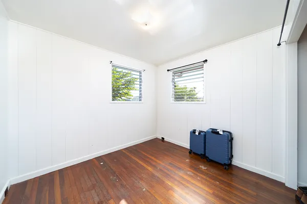 an empty room with wooden floor and window