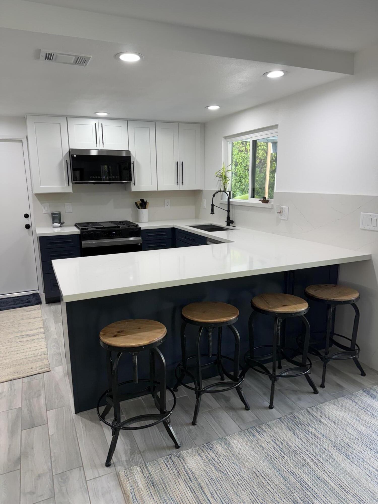 37081 Palmdale Road Rancho Mirage, CA 92270 - Photo 19 of 46 a kitchen with stainless steel appliances granite countertop a table chairs sink and cabinets