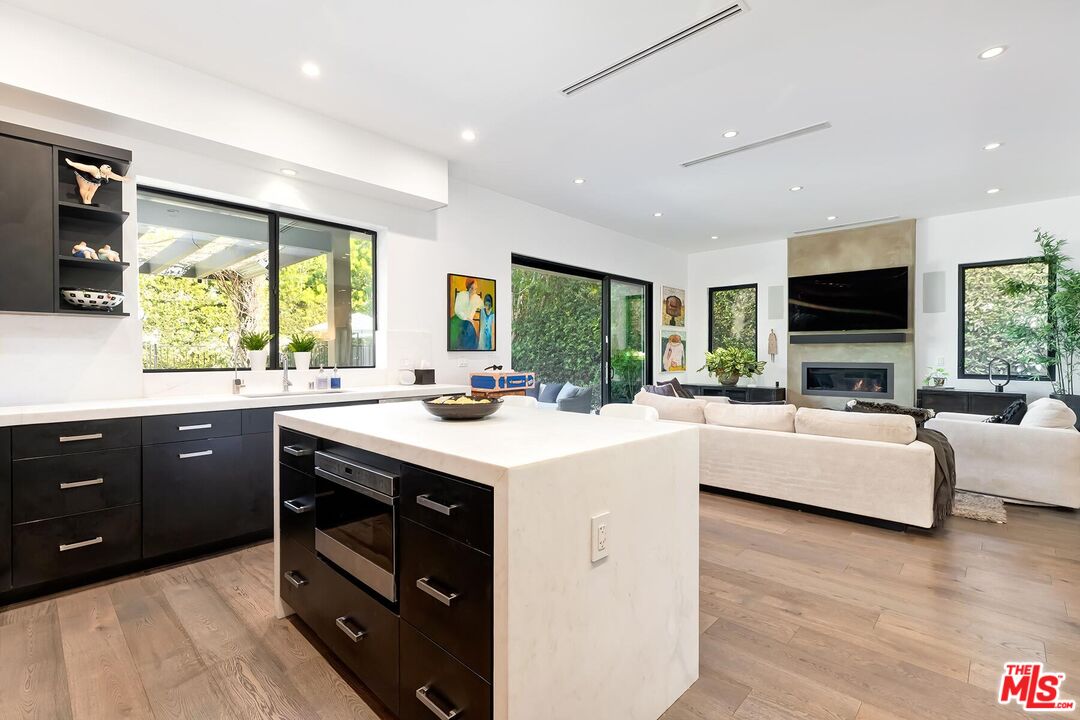10521 Northvale Road Los Angeles, CA 90064 - Photo 24 of 52 a kitchen with kitchen island granite countertop a sink stove and wooden floor