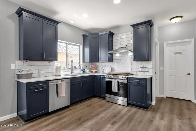 a kitchen with stainless steel appliances granite countertop a sink stove and refrigerator
