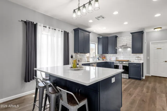 a kitchen with a refrigerator a sink dishwasher with a dining table and chairs