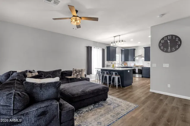 a living room with furniture kitchen view and a chandelier