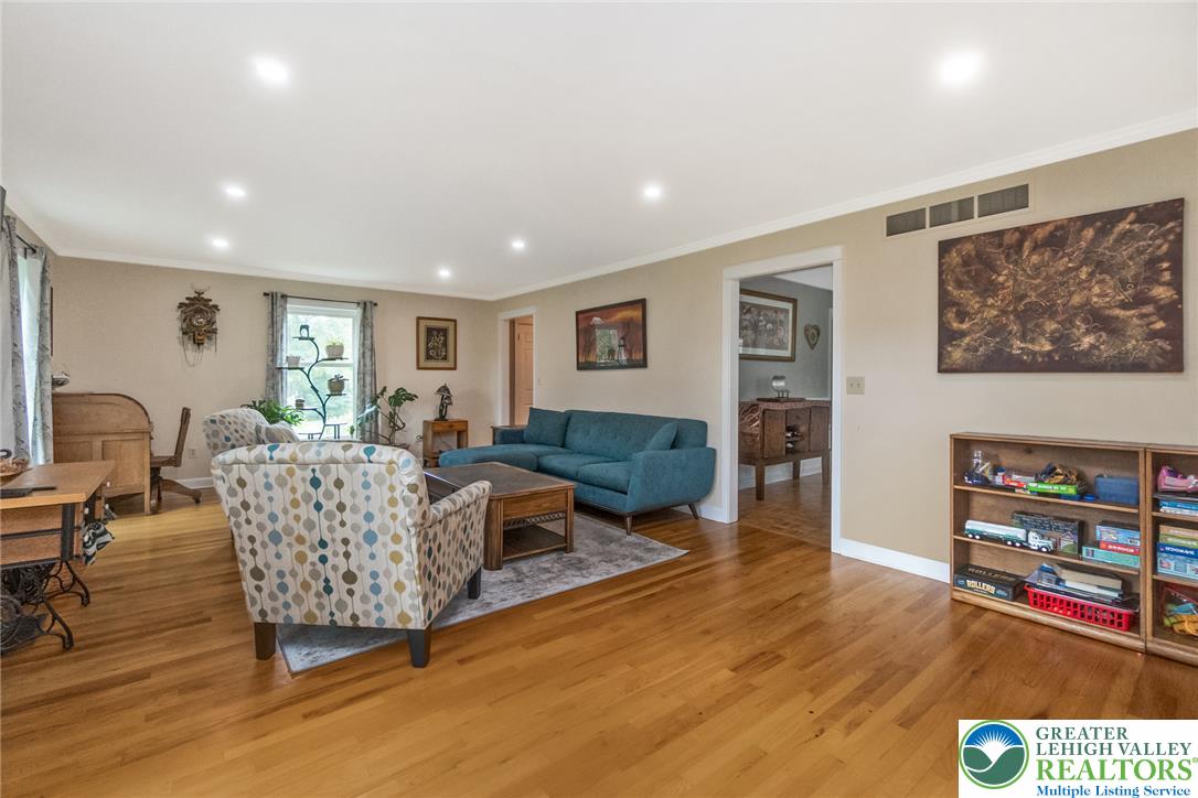 1553 Surrey Road Bethlehem, PA 18015 - Photo 18 of 92 Recessed lighting illuminates the living space, complemented by polished hardwood floors that extend throughout the room.