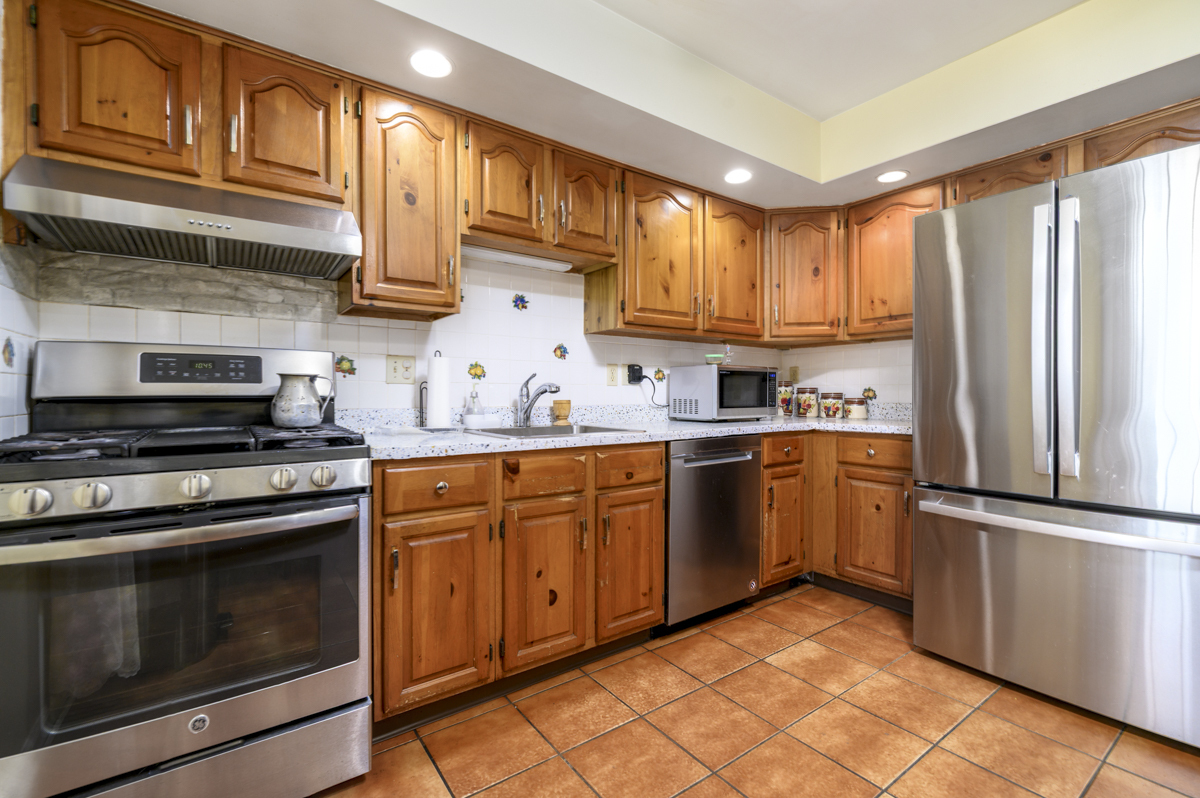 209 Seaside Avenue, Unit 2 Stamford, CT 06902 - Photo 6 of 19 a kitchen with granite countertop wooden cabinets stainless steel appliances and a window