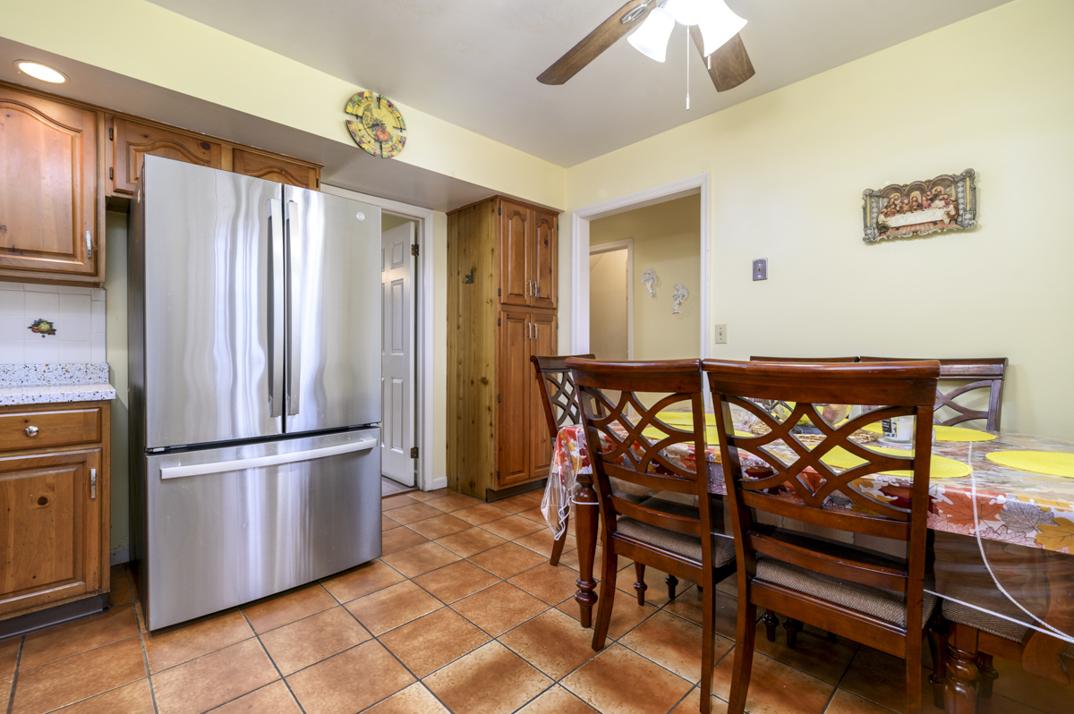 209 Seaside Avenue, Unit 2 Stamford, CT 06902 - Photo 8 of 19 a kitchen with granite countertop a refrigerator dining table and stainless steel appliances
