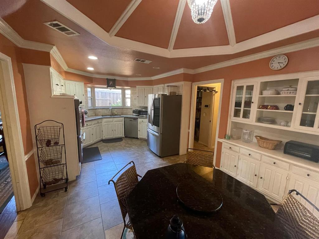 3612 Cross Bend Road Plano, TX 75023 - Photo 21 of 38 Tiled dining space featuring an inviting chandelier, sink, ornamental molding, and a raised ceiling