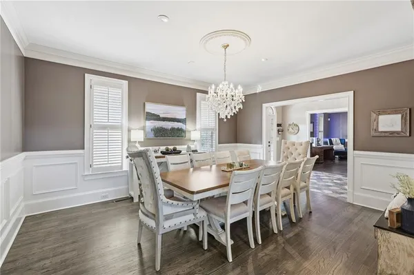 a living room with couches and kitchen view with wooden floor