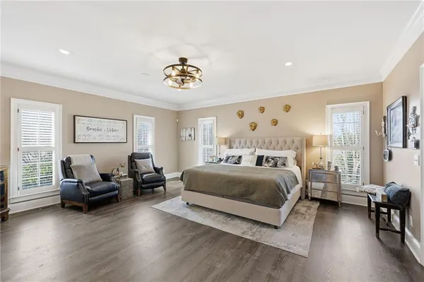 a bedroom with a large bed and a chandelier