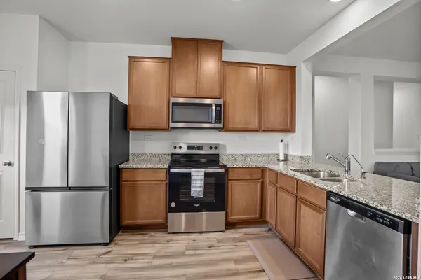 a kitchen with stainless steel appliances granite countertop a refrigerator stove a sink and a microwave