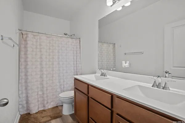a bathroom with a sink a toilet and shower curtain