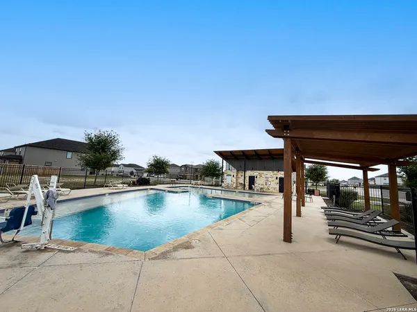 a view of a swimming pool with outdoor seating and plants