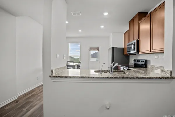a view of a kitchen with granite countertop stainless steel appliances granite countertop a sink and a granite counter tops