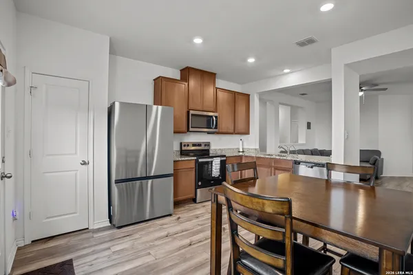 a kitchen with kitchen island a counter top space stainless steel appliances cabinets and wooden floor