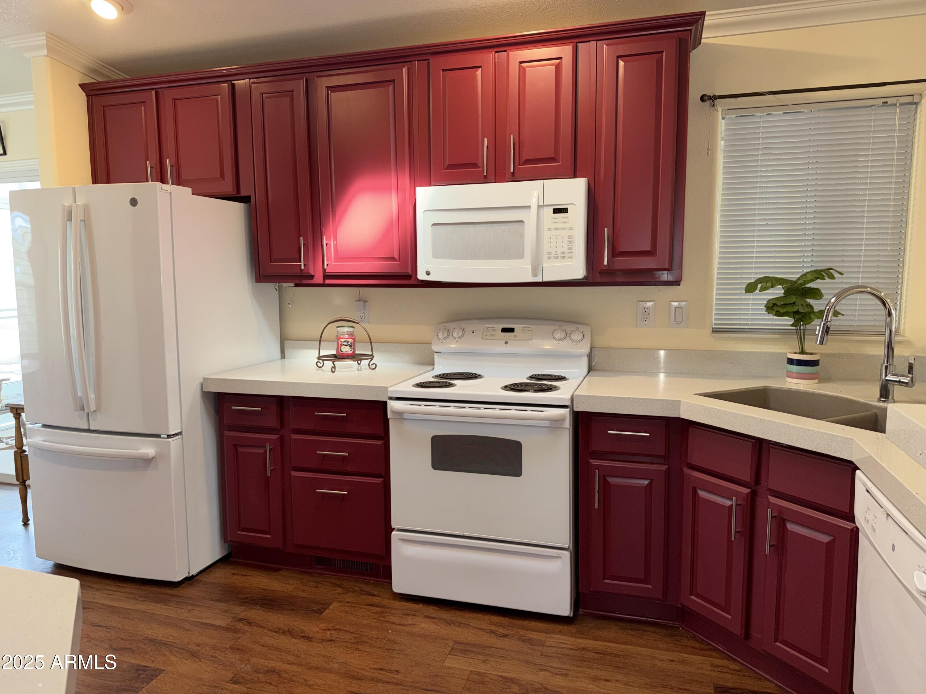 2929 East Main Street, Unit 219 Mesa, AZ 85213 - Photo 10 of 56 a kitchen with stainless steel appliances granite countertop a refrigerator stove a sink and dishwasher with wooden floor