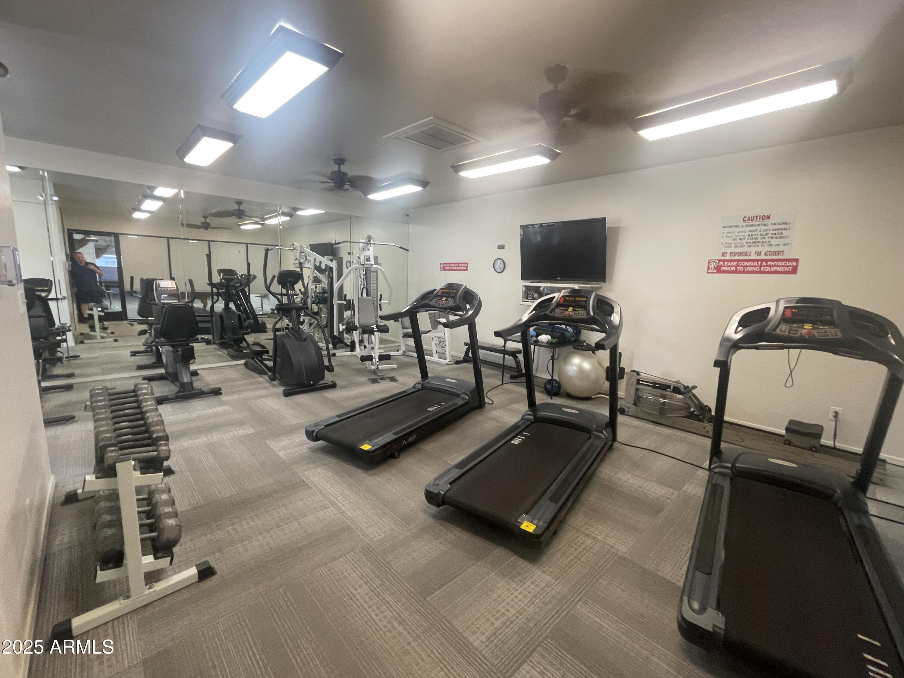 2929 East Main Street, Unit 219 Mesa, AZ 85213 - Photo 41 of 56 a room with gym equipment and a flat screen tv