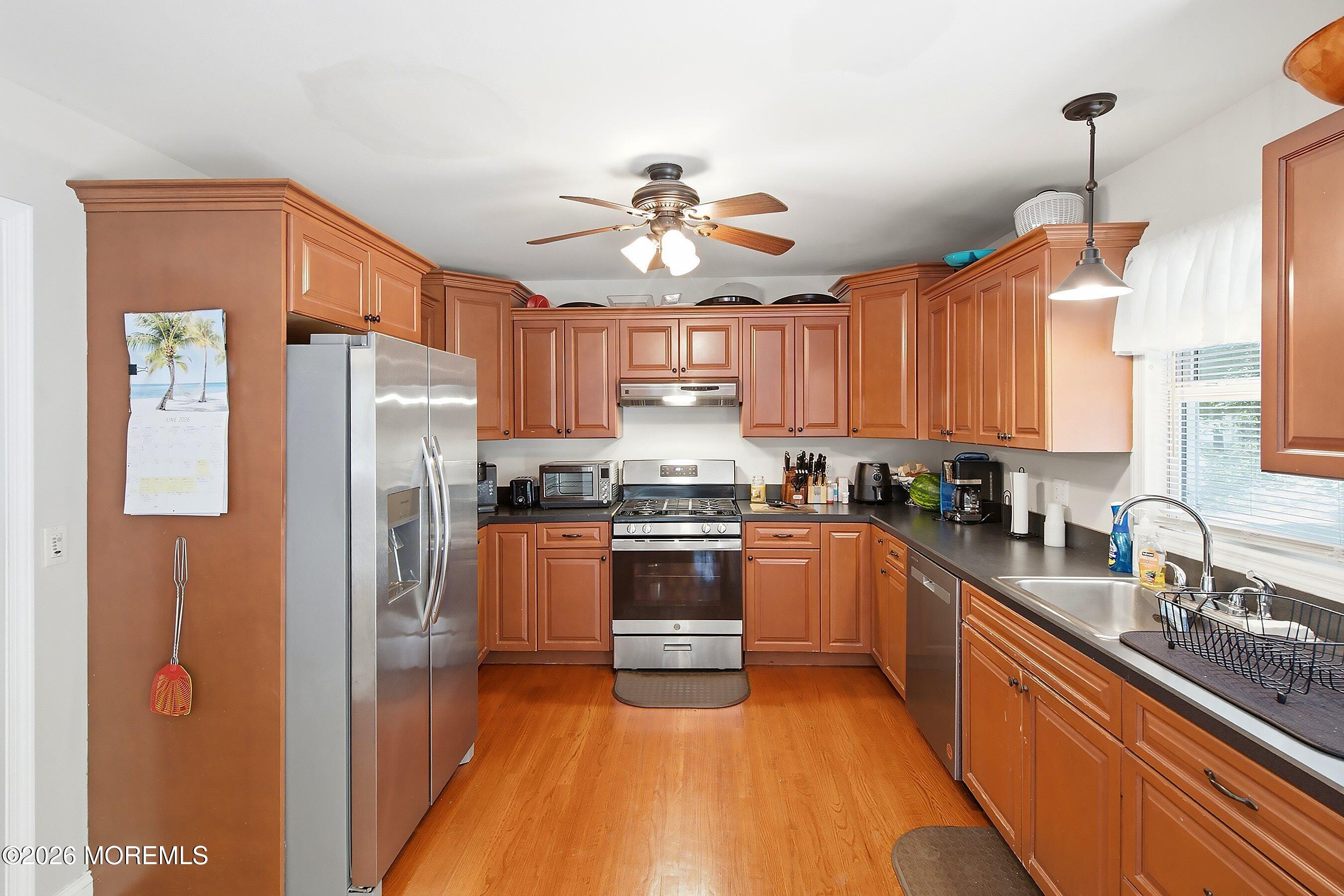 935 Bethel Church Road Jackson, NJ 08527 - Photo 10 of 32 a kitchen with stainless steel appliances granite countertop a refrigerator a sink dishwasher a stove and a dining table with wooden floor
