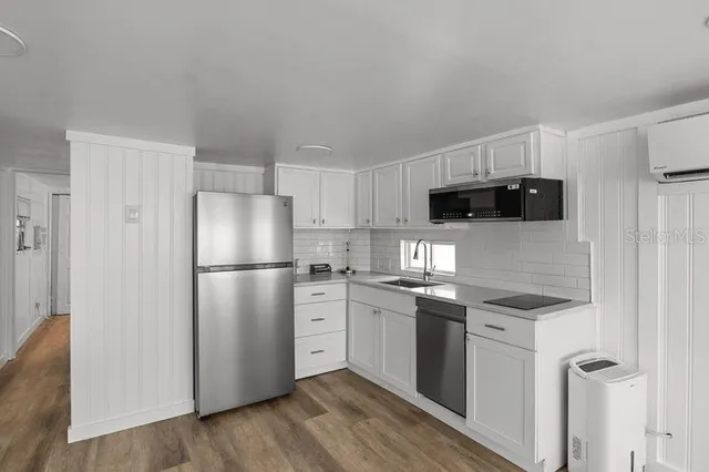a kitchen with stainless steel appliances a refrigerator sink and microwave