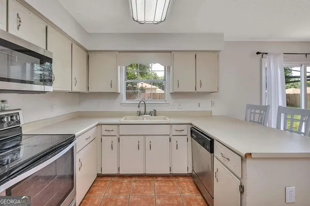 a kitchen with a sink stove and cabinets
