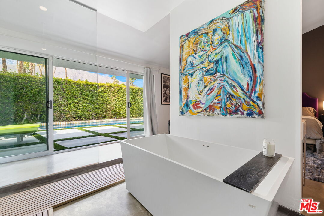 1155 East Mesquite Avenue Palm Springs, CA 92264 - Photo 17 of 32 a living room with a large window and white walls